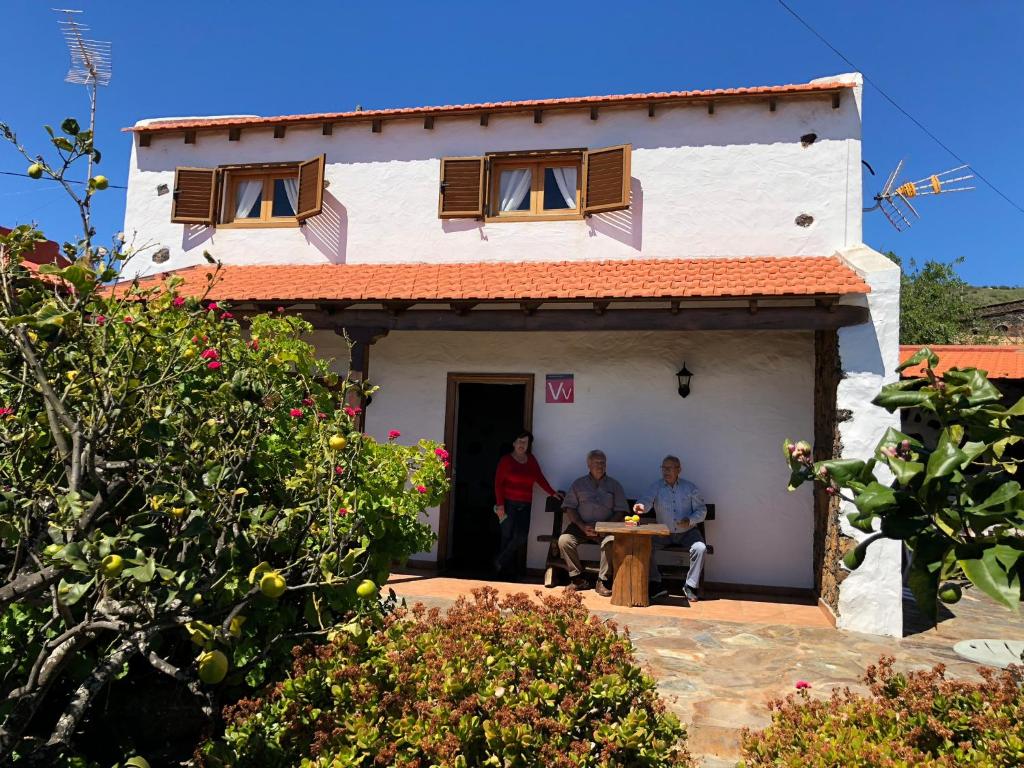 twee mensen aan een tafel buiten een huis bij Casa La Fuente in Isora