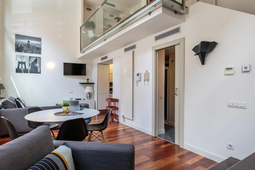 ein Wohnzimmer mit einem Sofa und einem Tisch in der Unterkunft Modern and Trendy Duplex next to Paseo de Gracia in Barcelona