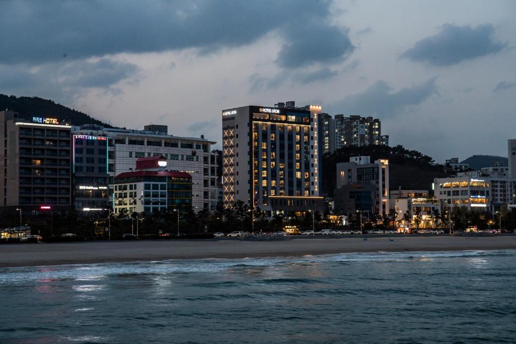 釜山的住宿－拉昂酒店，一座城市,晚上有海滩和建筑