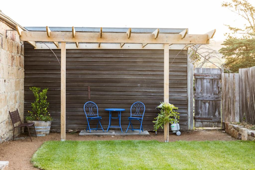 a pergola with two chairs and a table in a yard at Daisy Bank Cottages in Richmond