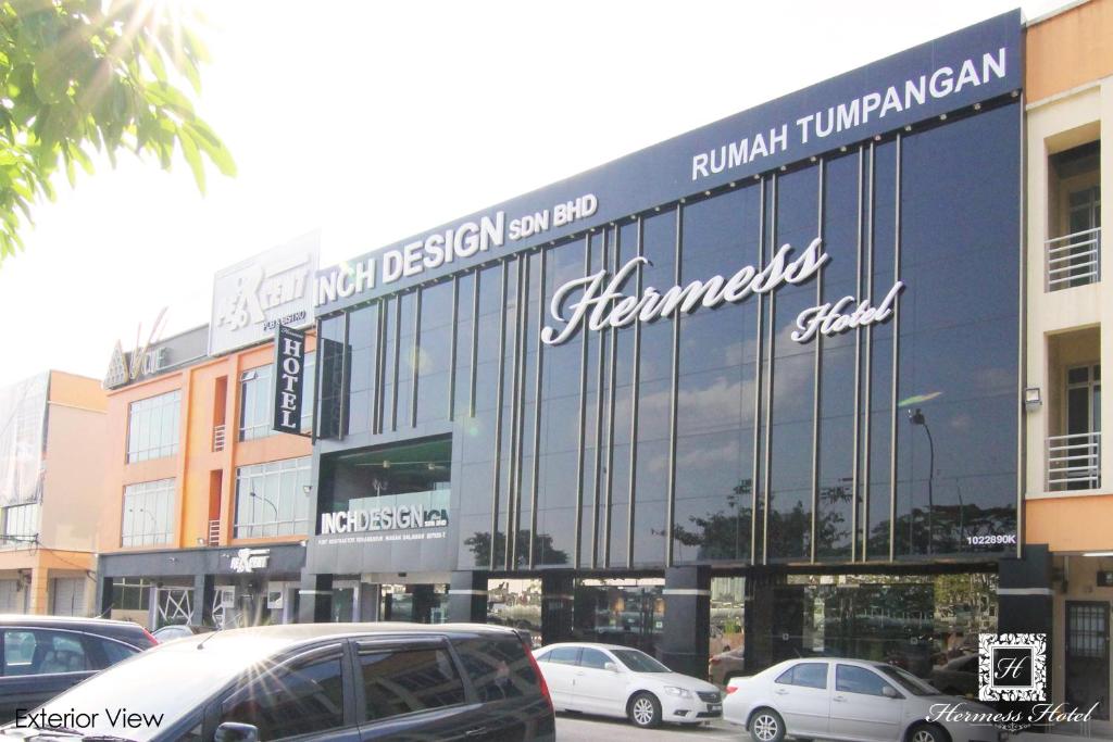 a large glass building with cars parked in front of it at Hermess Hotel Johor in Johor Bahru