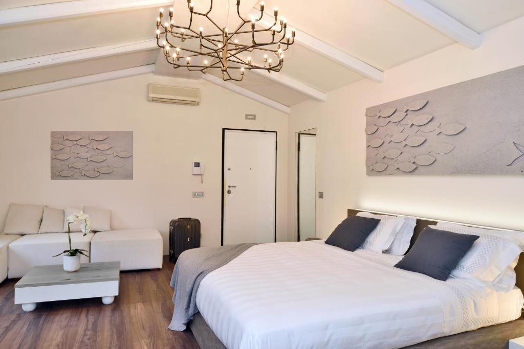 a bedroom with a large white bed and a chandelier at Terra Prime Suite in Riomaggiore