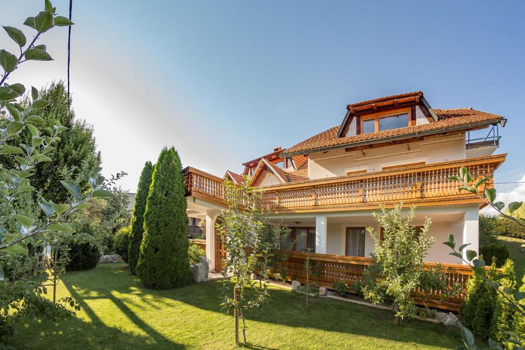 una casa grande con un patio con árboles en Apartments Ivana, en Bled