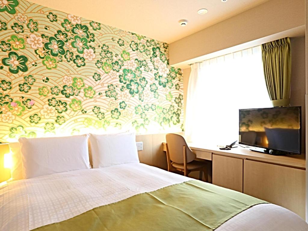 Hotel Wing International Premium Kanazawa Ekimae tesisinde bir odada yatak veya yataklar