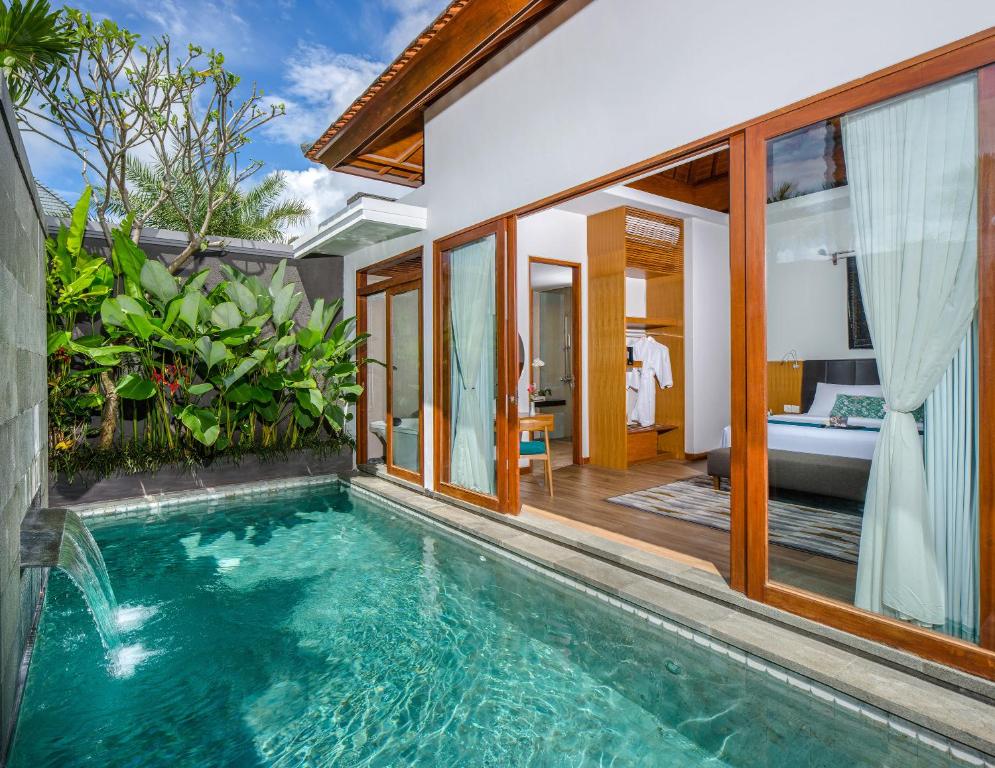 an infinity pool in a villa with a bedroom at S18 Bali Villas in Legian