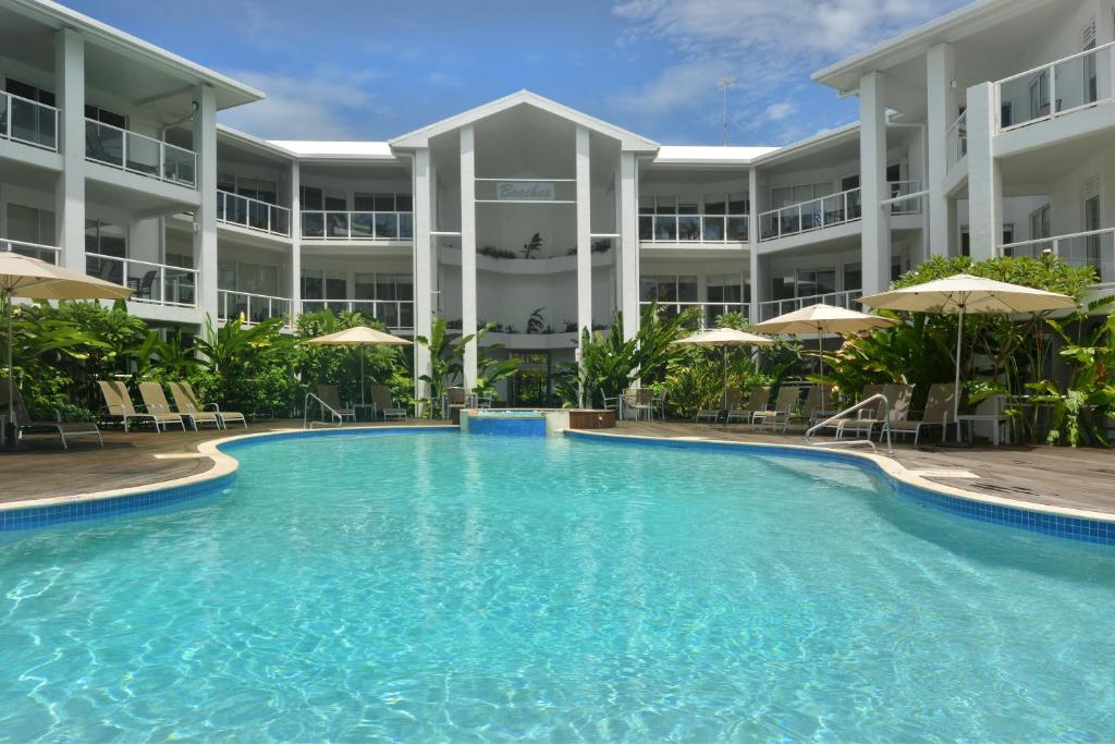 a large swimming pool in front of a building at Seascape Holidays at Beaches Port Douglas in Port Douglas