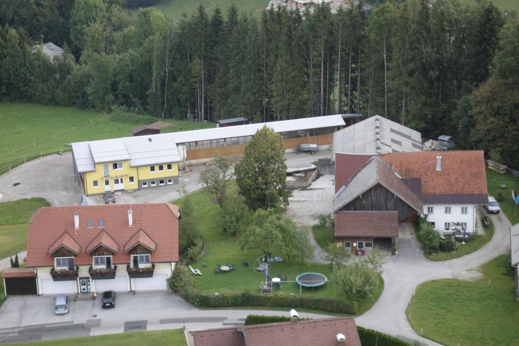 une vue aérienne sur un bâtiment avec un parking dans l'établissement Ferienhof Kehlbauer, à Hof bei Salzburg