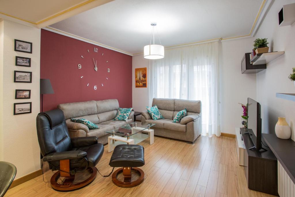 a living room with a couch and a chair at Apartamentos Abula in Ávila