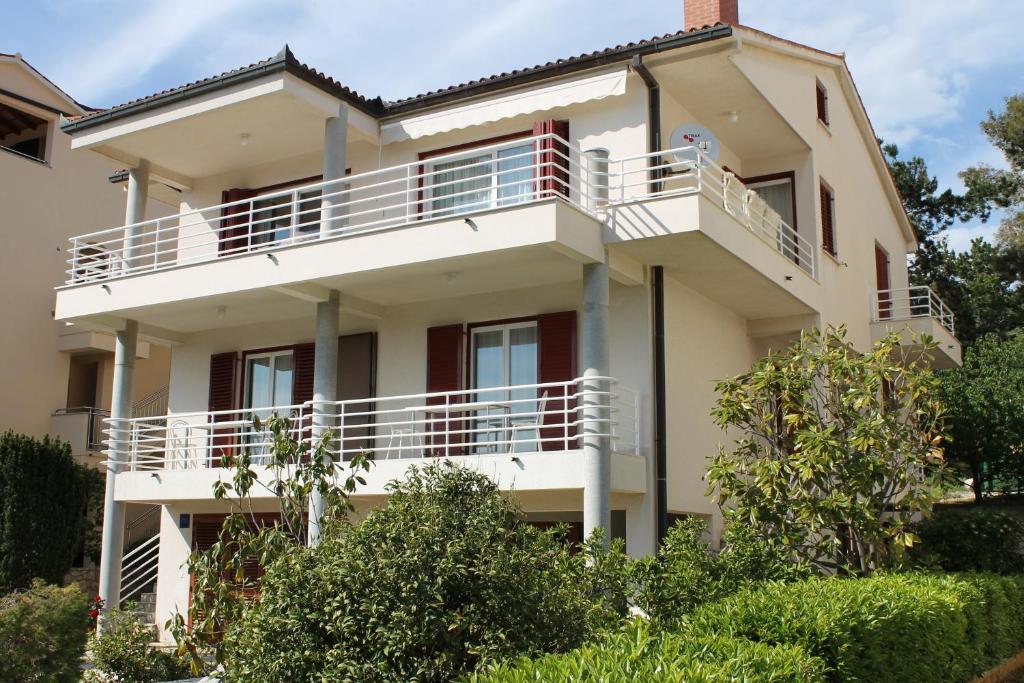 a building with a balcony on the side of it at Apartments Vila Marica in Rabac