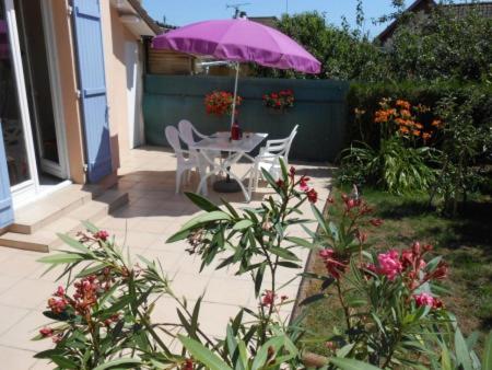 d'une terrasse avec une table et un parasol violet. dans l'établissement Gite B, à Sotteville-lès-Rouen