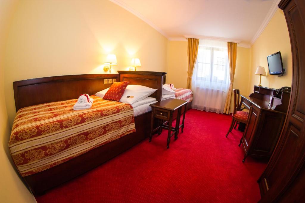 a hotel room with two beds and a red carpet at Hotel U Krále in Jičín