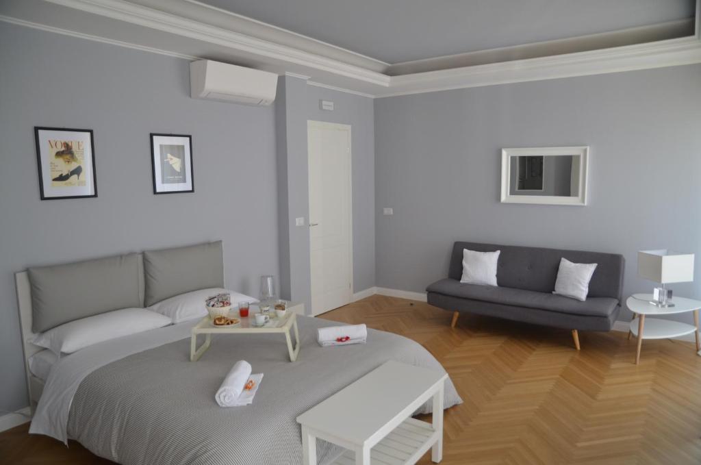 a white bedroom with a bed and a couch at Room 56 in Bari