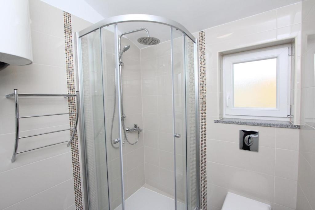 W łazience znajduje się prysznic ze szklanymi drzwiami. w obiekcie Apartments Sorriso w Rovinj