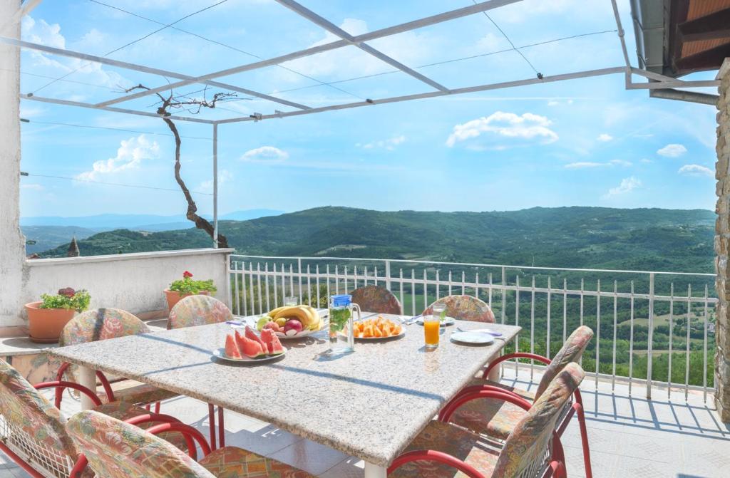 a table and chairs on a balcony with a view at Apartment Stella in Motovun