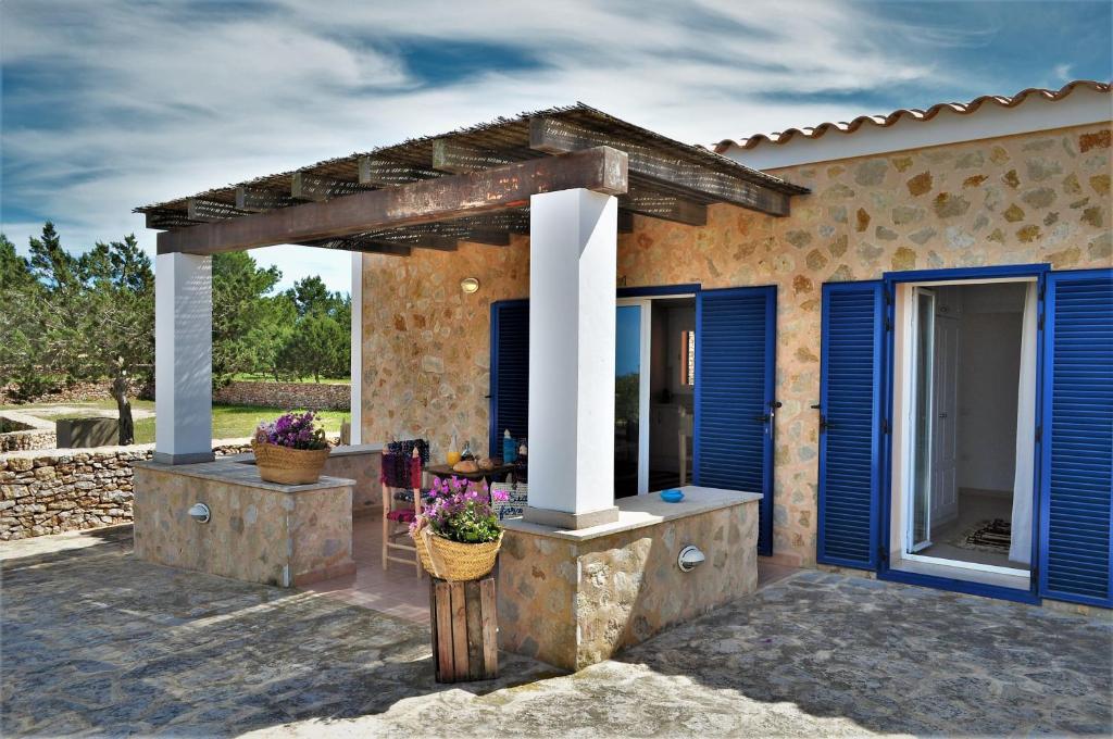 a patio of a house with blue shutters at Siamoformentera Valentina in Sant Francesc Xavier