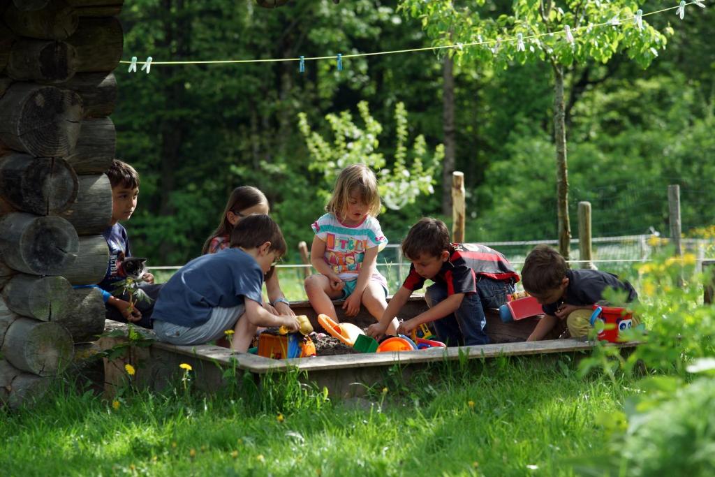 eine Gruppe von Kindern, die mit Spielzeug in einem Sandkasten spielen in der Unterkunft Ferienbauernhof Schneider in Schwarzenberg im Bregenzerwald