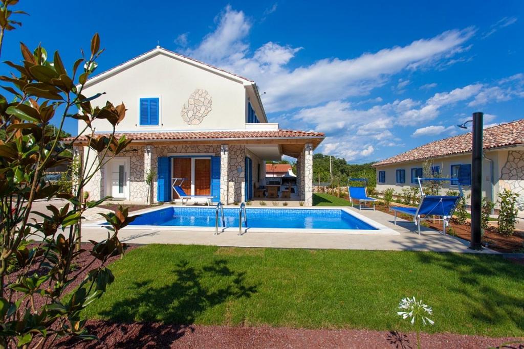 a villa with a swimming pool and a house at Villa Milohnici Florian in Milohnići