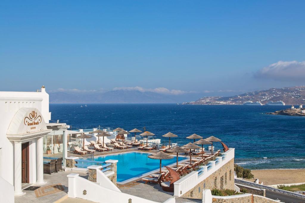 a view of a resort with a swimming pool and the ocean at Grand Beach Hotel in Mikonos