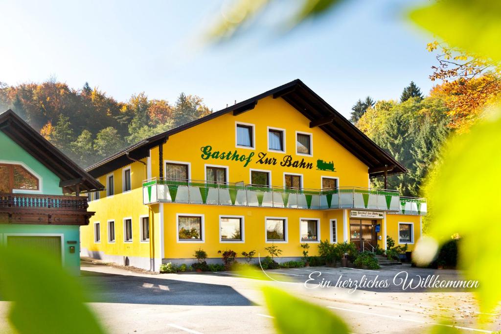 d'un grand bâtiment jaune avec un panneau. dans l'établissement Gasthof "zur Bahn", à Lassnitzhöhe