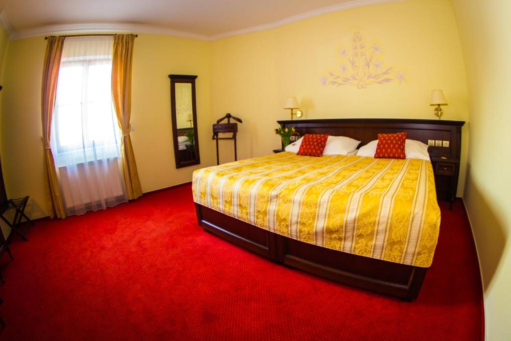 a bedroom with a bed and a red carpet at Hotel U Krále in Jičín