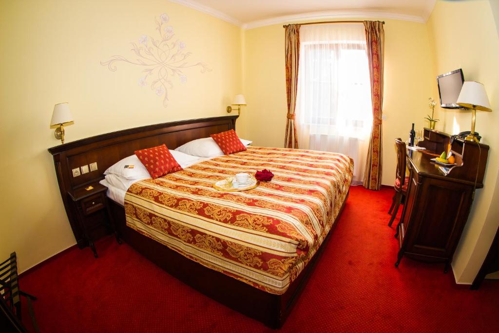 a hotel room with a bed and a desk at Hotel U Krále in Jičín