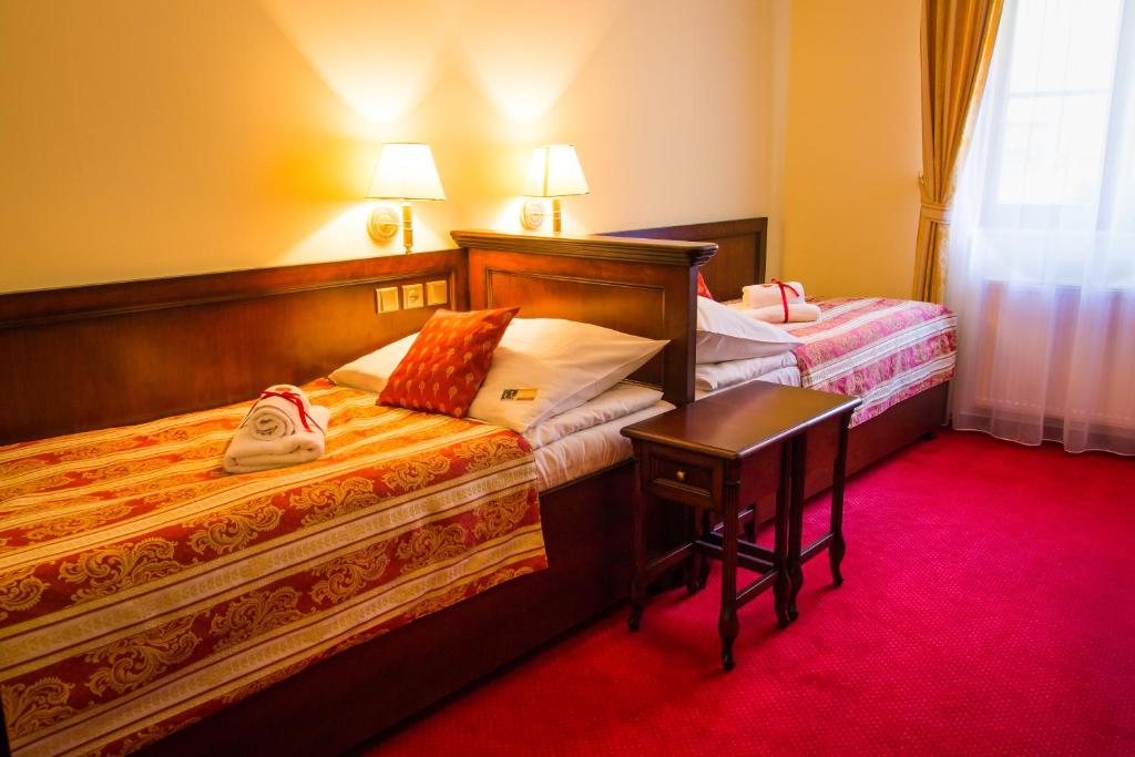 a hotel room with two beds and a desk at Hotel U Krále in Jičín
