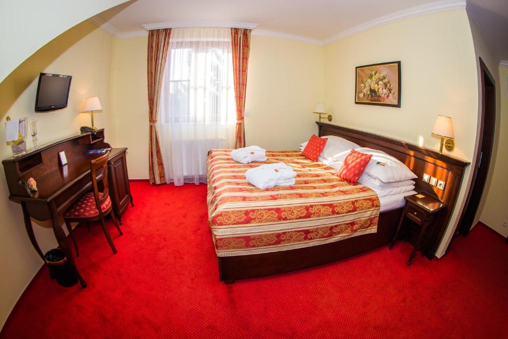 a bedroom with a bed with a red carpet at Hotel U Krále in Jičín