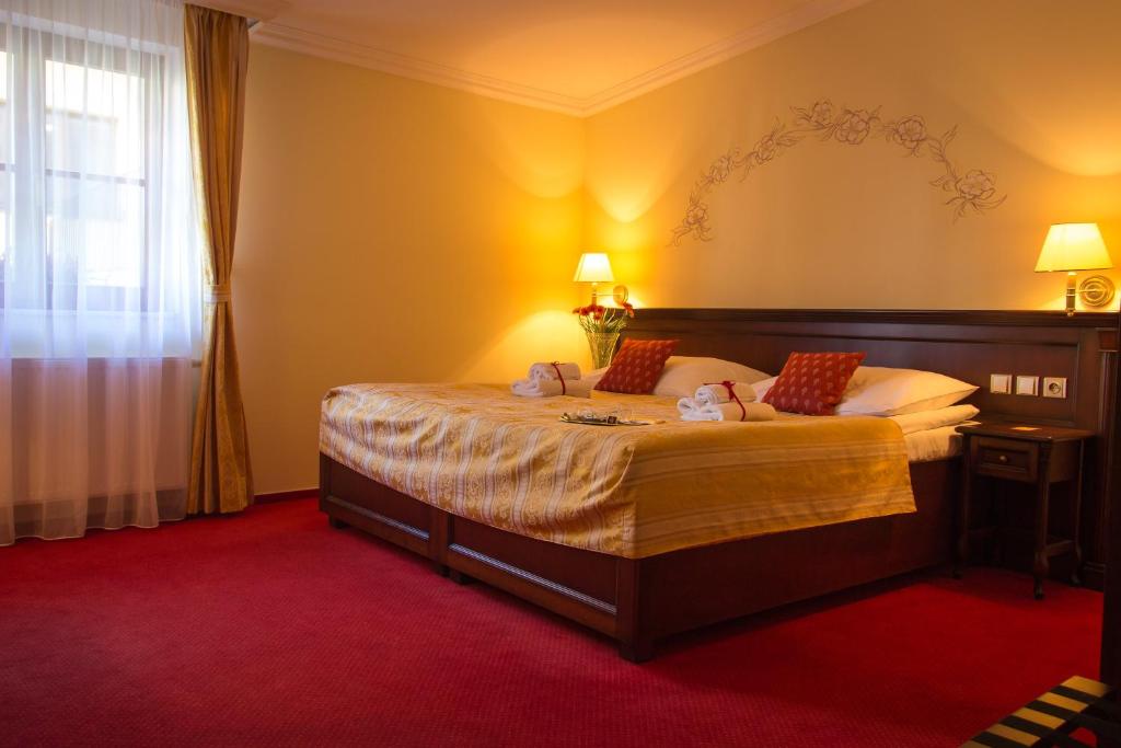 a bedroom with a bed with two stuffed animals on it at Hotel U Krále in Jičín