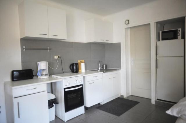 a small kitchen with white cabinets and a appliance at Mas Vincent in La Fare-les-Oliviers