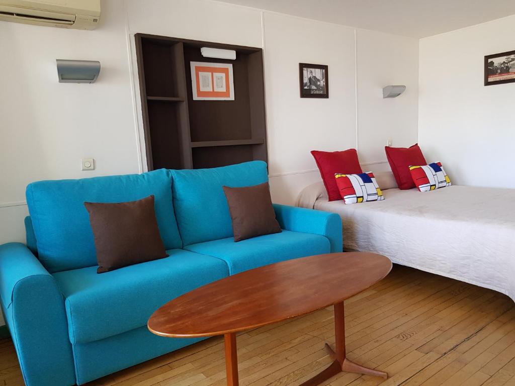 a blue couch and a table in a room with a bed at Hotel le Corbusier in Marseille