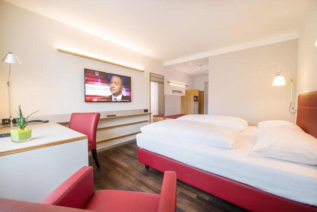 una camera d'albergo con due letti e un tavolo con sedie di Hotel Rommel a Korb