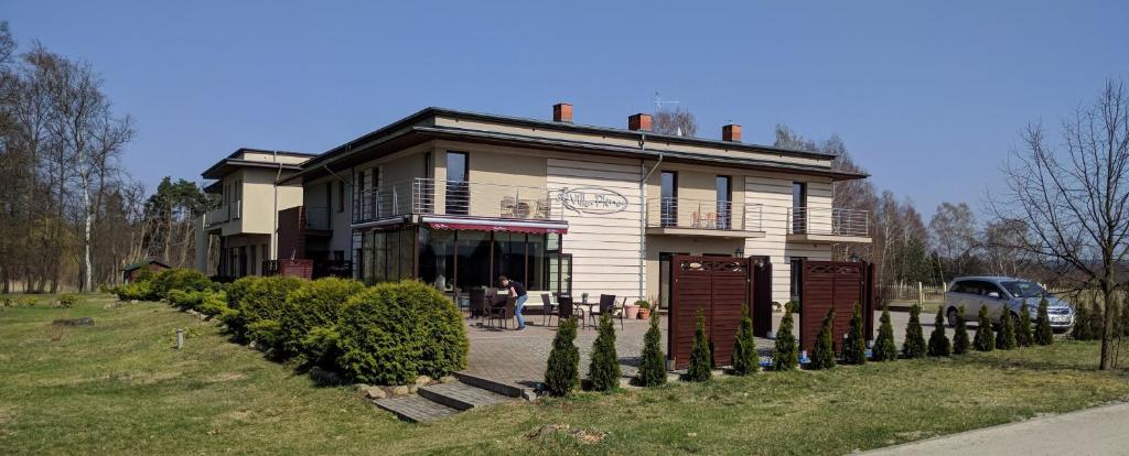 une maison avec une femme debout devant elle dans l'établissement Villa Plena, à Ośno Lubuskie