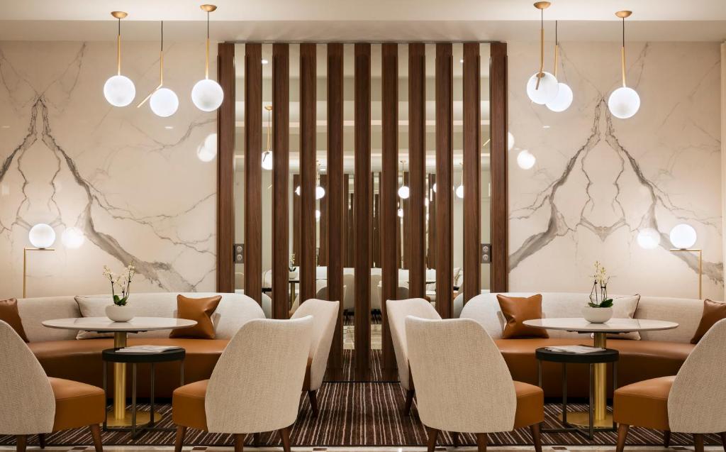 a restaurant with tables and chairs and lights at Hôtel Barrière Le Gray d'Albion in Cannes