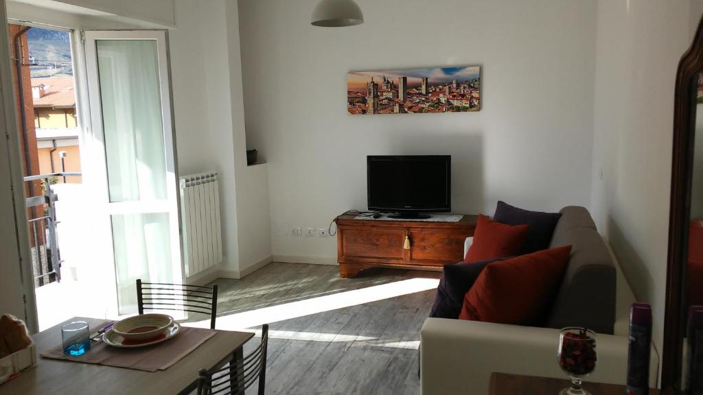 Appartamento Miro في سان بيليغرينو تيرمي: غرفة معيشة مع أريكة وتلفزيون