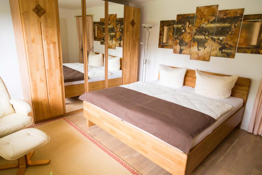 1 dormitorio con 1 cama grande y espejo en Ferienwohnung Königswinter en Königswinter