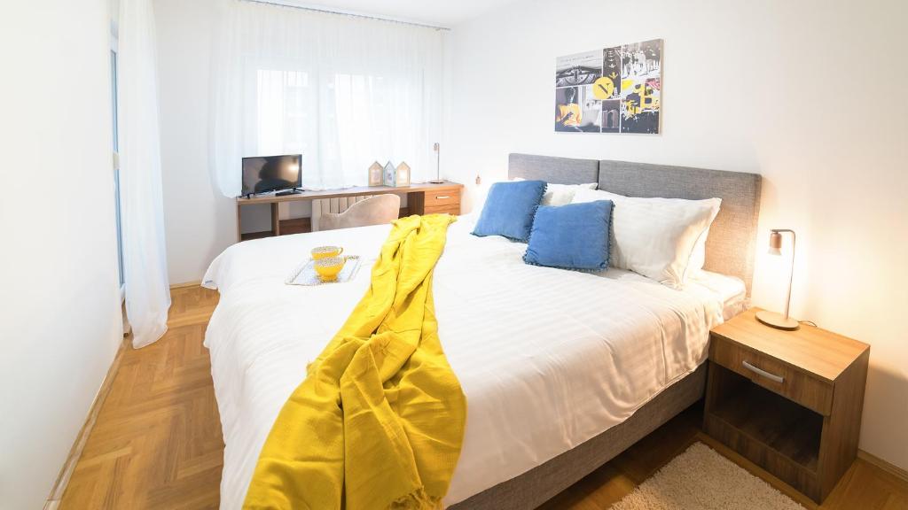 um quarto com uma cama grande com um cobertor amarelo em Novel Inn em Belgrado