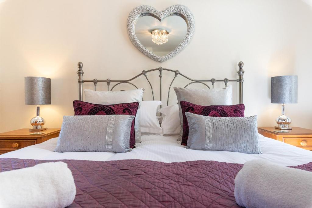 a bedroom with a bed with a heart mirror on the wall at Wolfen Mill in Chipping