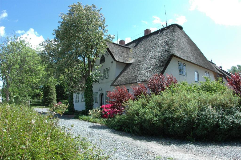 a large white house with a thatched roof at Hof Luisengrund in Tating