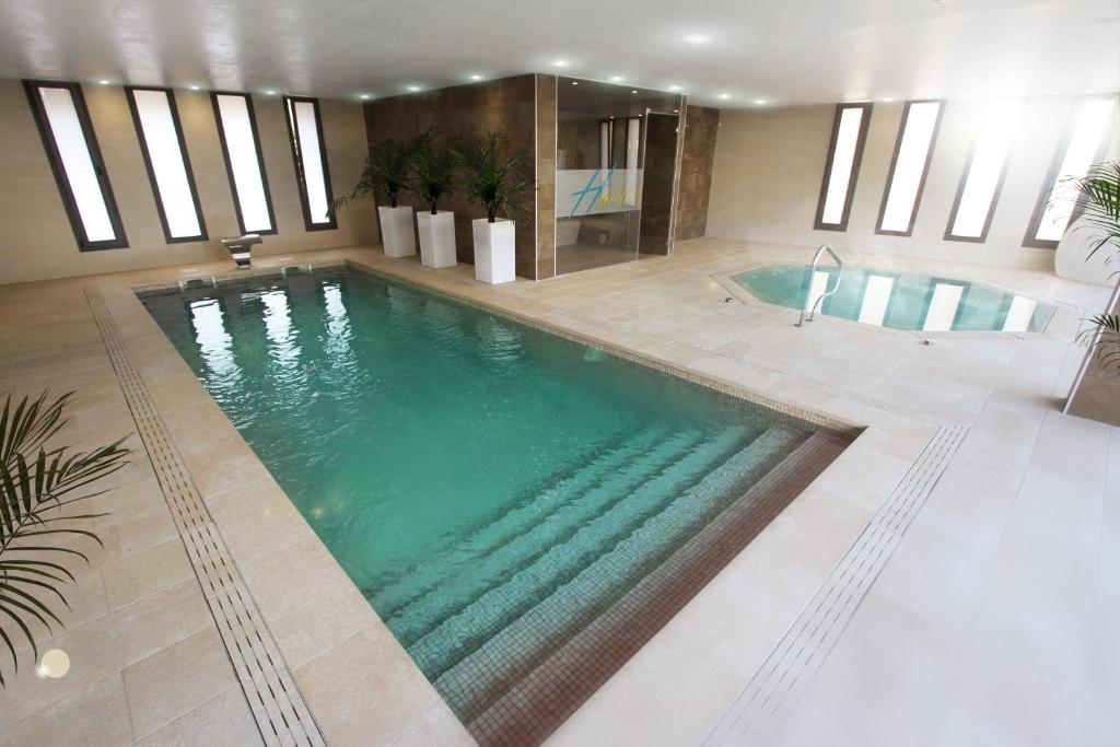 a large swimming pool in a hotel room with a pool at Apartamentos Cambrils Playa Spa in Cambrils