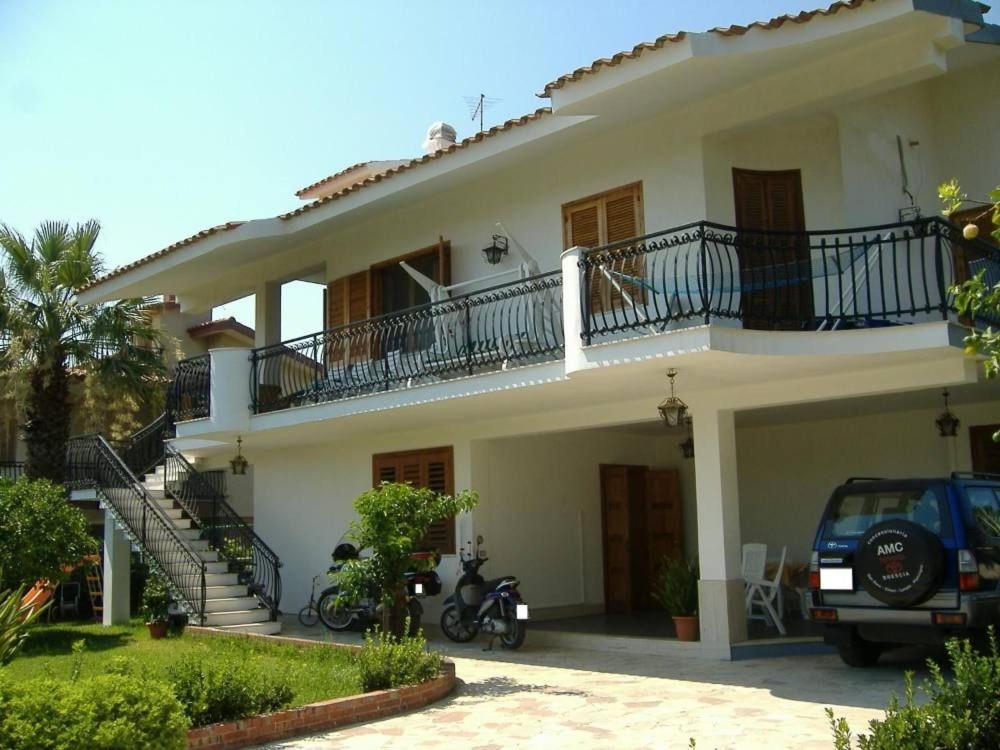 a white house with a motorcycle parked in front of it at Appartamento in villa a Fontane Bianche in Fontane Bianche