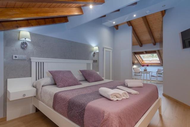 a bedroom with a large bed with two towels on it at Hotel La Terraza De Puente Viesgo in Puente Viesgo