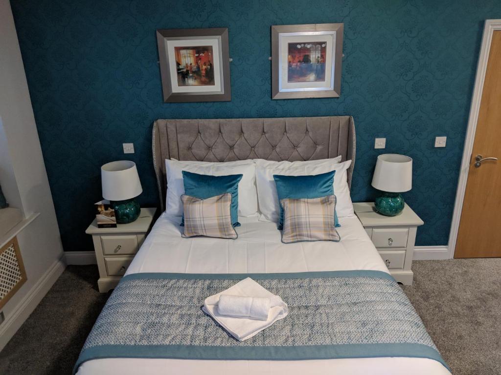 a bedroom with a large bed with blue walls at The Portland in Ashington