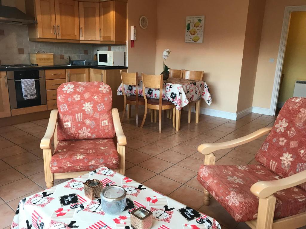 a living room with a table and chairs and a kitchen at Kings Court Holiday Apartments in Tralee