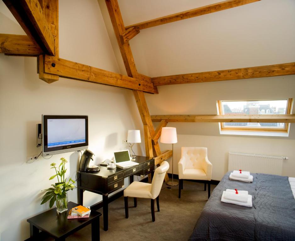 a bedroom with a desk and a computer in a room at Grand Hotel Alkmaar in Alkmaar