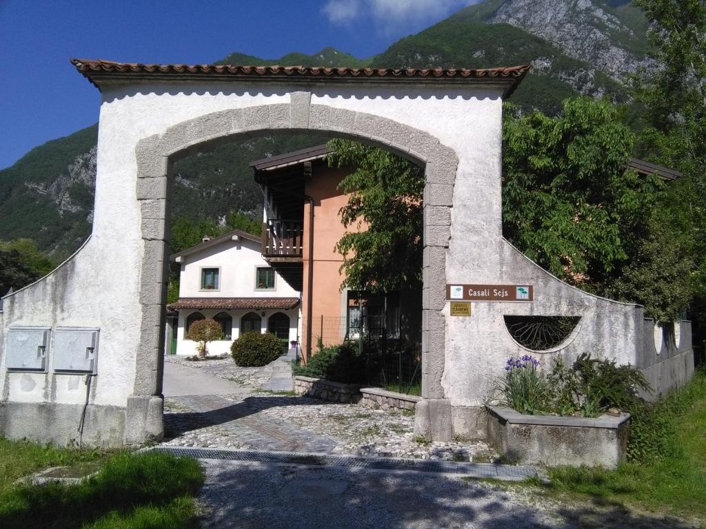 un bâtiment avec une arche en face d'une maison dans l'établissement Casali Scjs, à Venzone