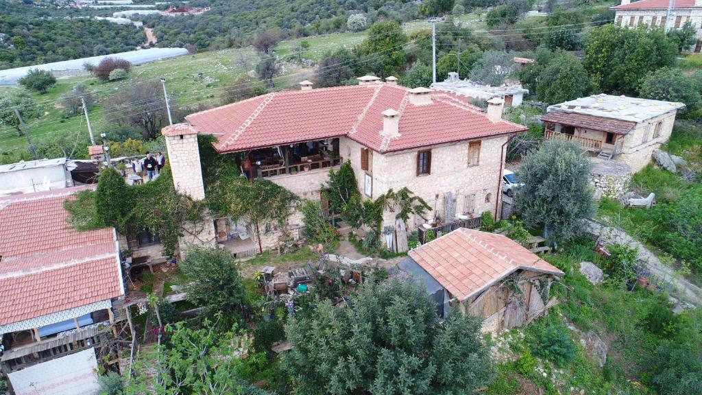 ein großes Haus mit rotem Dach auf einem Hügel in der Unterkunft Beymelek Tas Evler in Demre