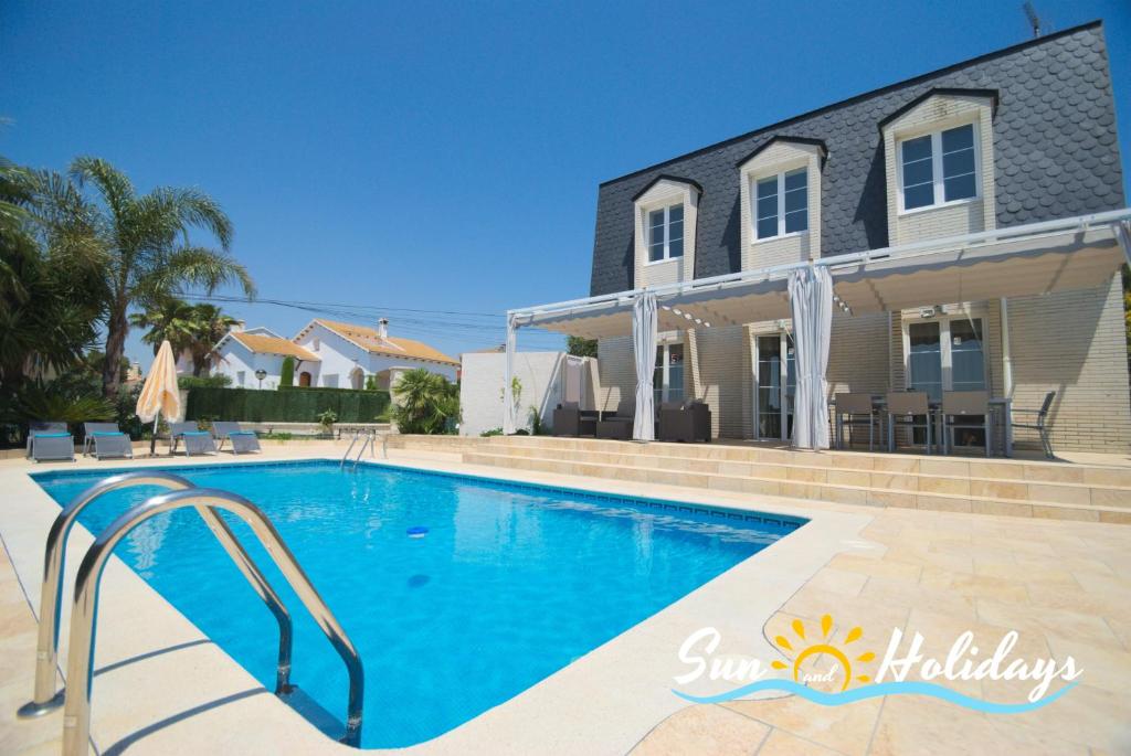 a swimming pool in front of a house at Villa Oasis in El Vendrell