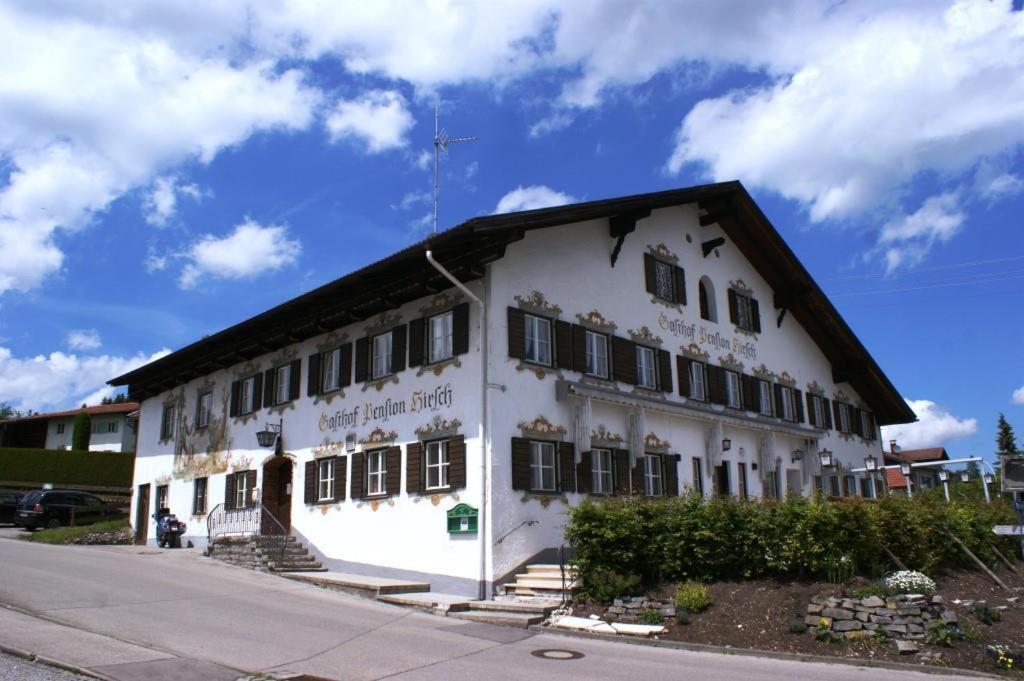 a white building with a black roof at Pension Hirsch in Lechbruck