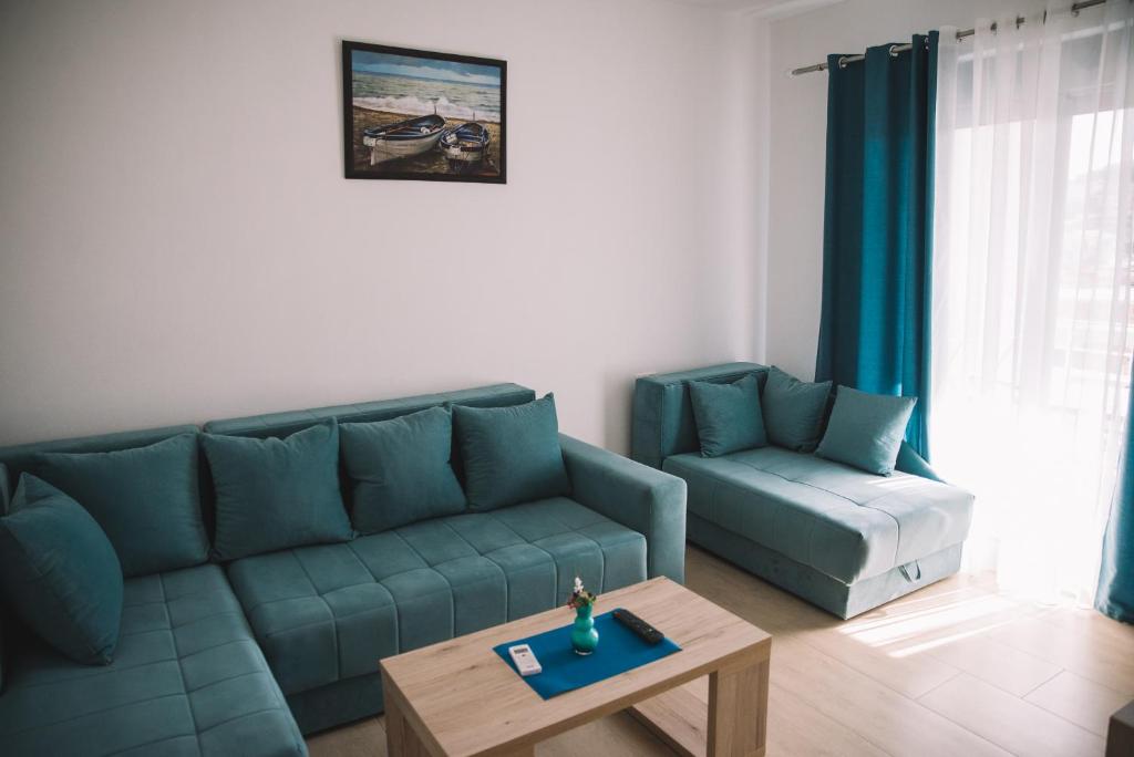 a living room with a blue couch and a coffee table at Sunrise Apart-Hotel in Ulcinj