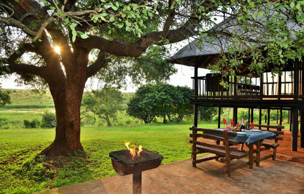 a picnic table and a fire grill in a park at Elephant Walk Retreat in Komatipoort